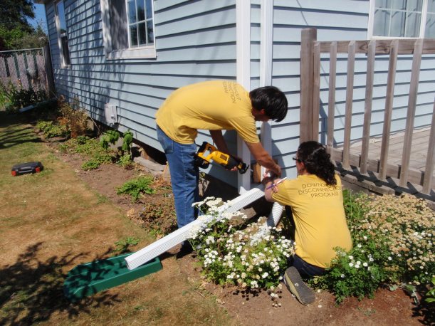 AmeriCorps volunteers disconnect downspouts